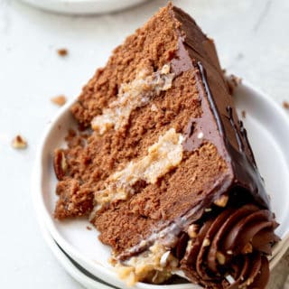 A close up of slice of German Chocolate Cake recipe on white plate ready to eat