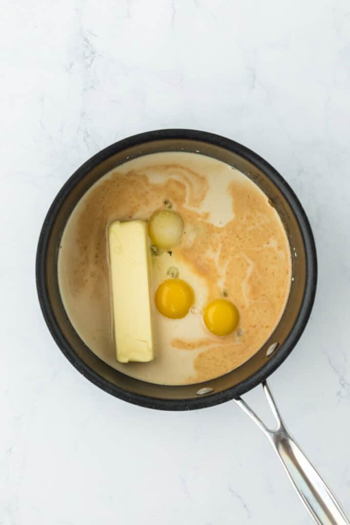 Evaporated milk, butter, eggs, salt and vanilla in a pot melting