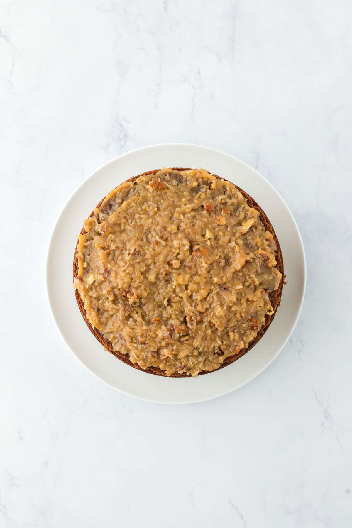 Finished german chocolate cake with icing on top.