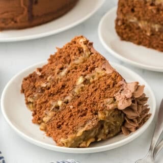 A slice of German cake on a white plate ready to serve