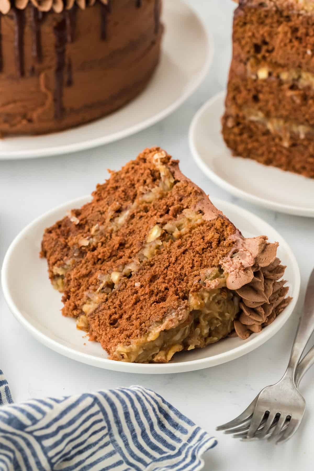 A slice of German cake on a white plate ready to serve