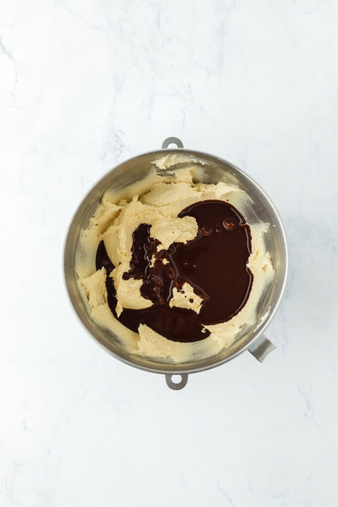 Melted chocolate in cake batter on white countertop.