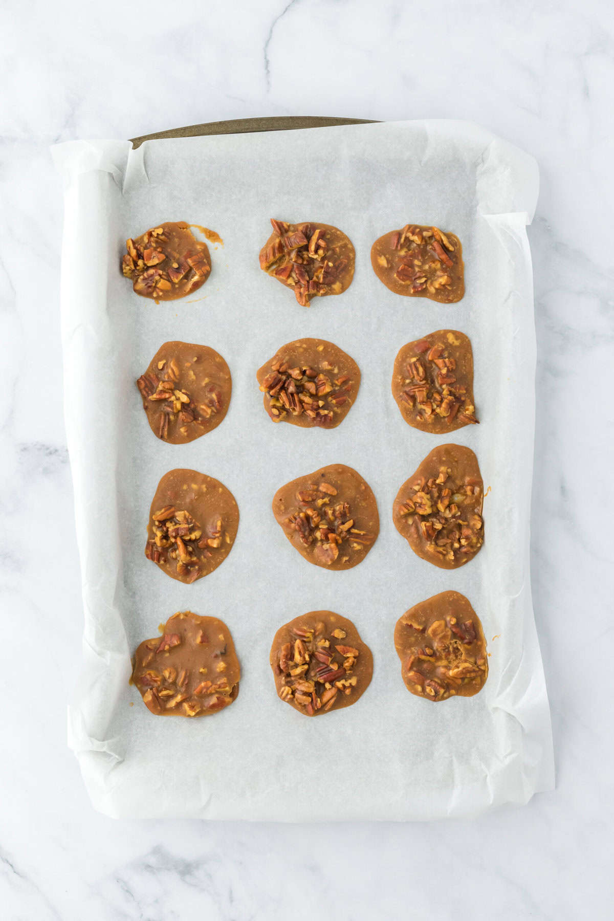 Cooled praline recipe on parchment paper on white background