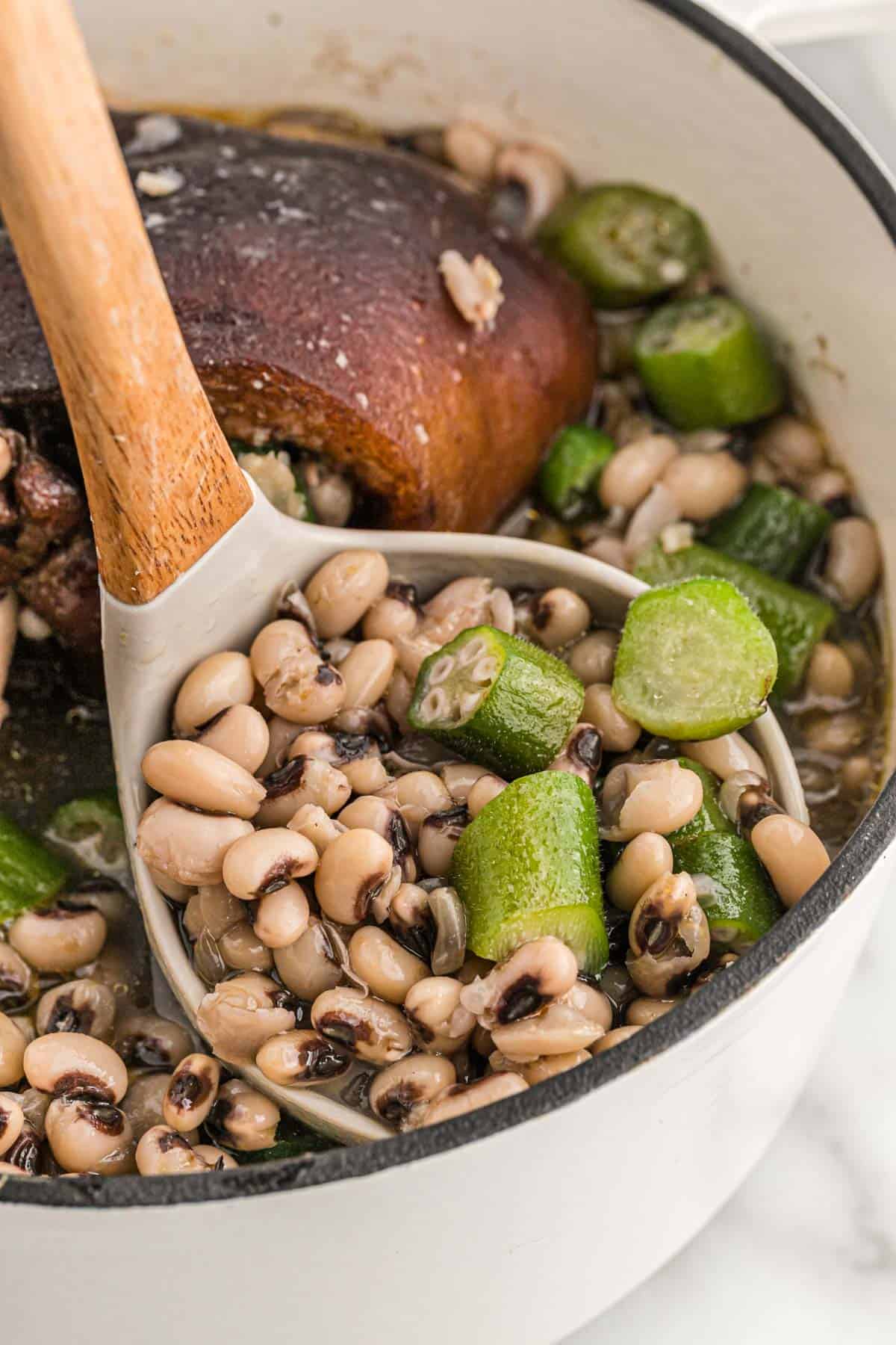 A ladle scooping into a pot of southern black eyed peas.