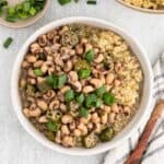 Two bowls of hoppin john recipe served on quinoa in white bowls ready to enjoy