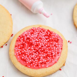 A single sugar cookie with pink frosting and sprinkles.