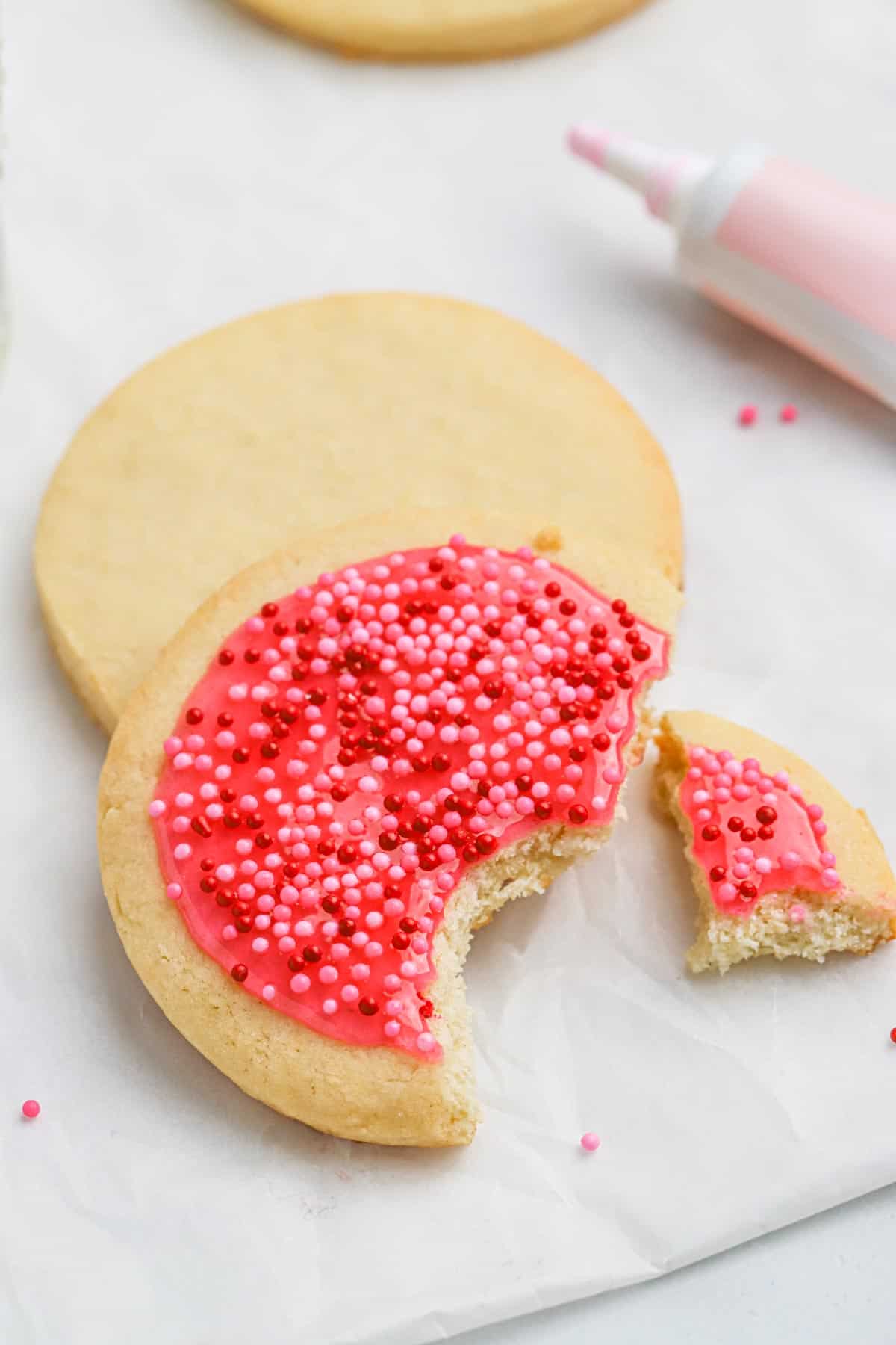 Delicious iced sugar cookies with a bite missing.
