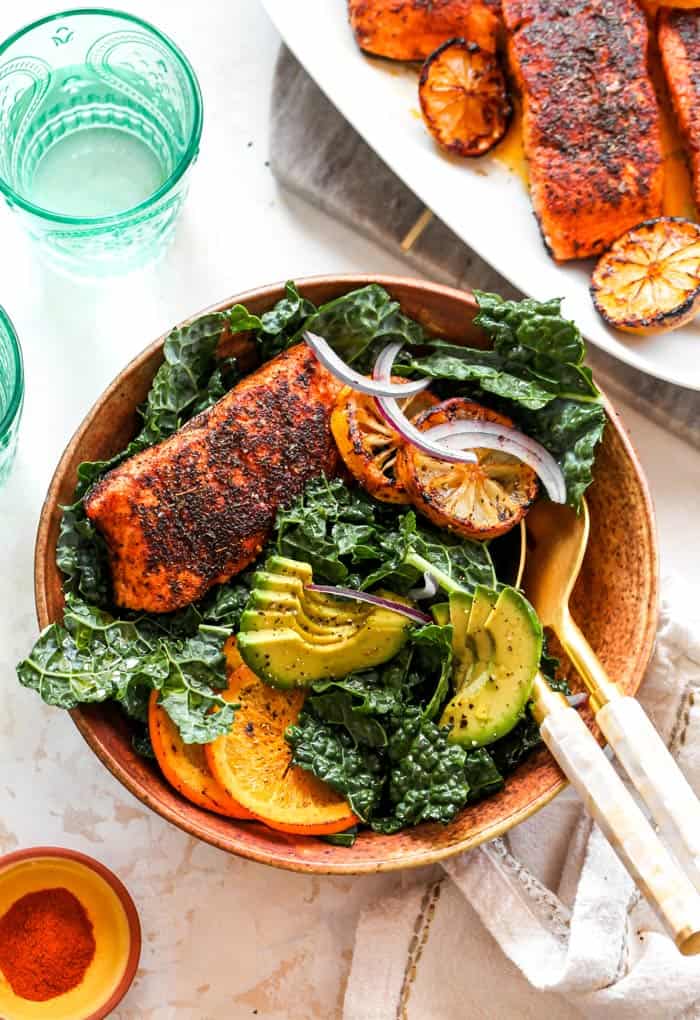 Blackened Salmon on a green salad with avocado ready to enjoy