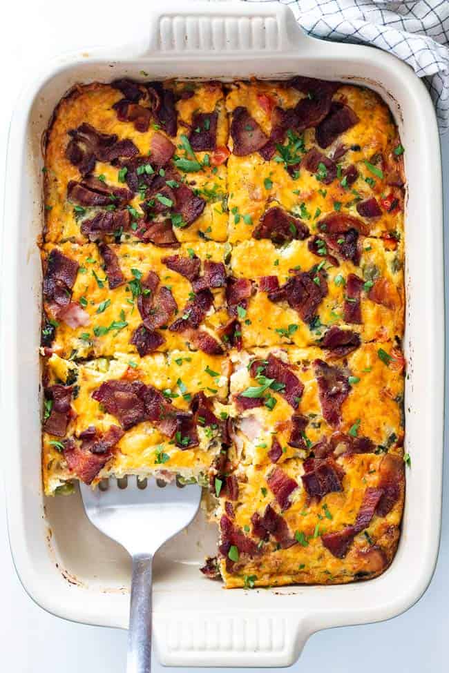 Breakfast bake recipe is cut into squares with a spatula ready to serve for brunch