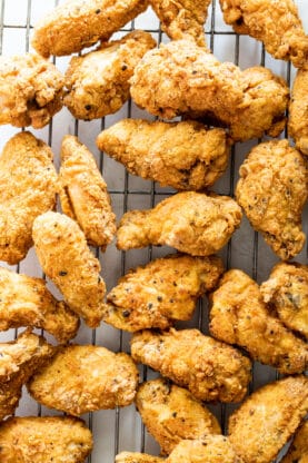 Fried chicken wings draining on wire rack