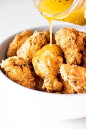 Delicious glaze being poured on Lemon pepper chicken wings recipe