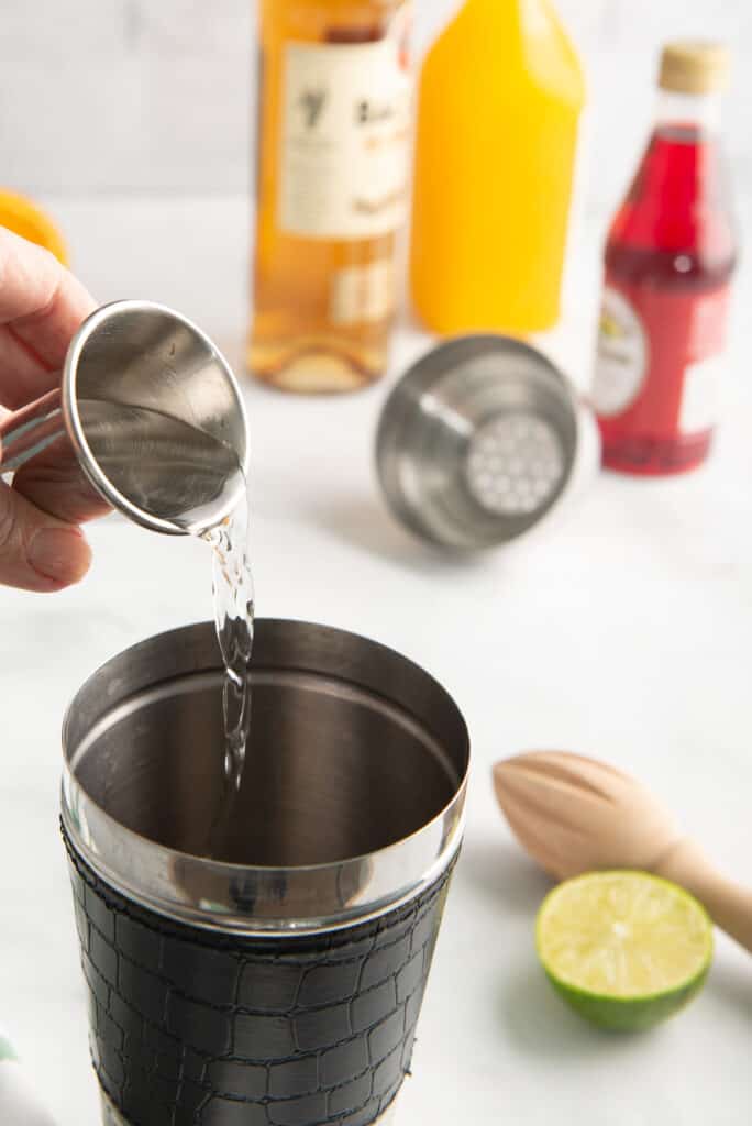 Rum being added to a cocktail shaker