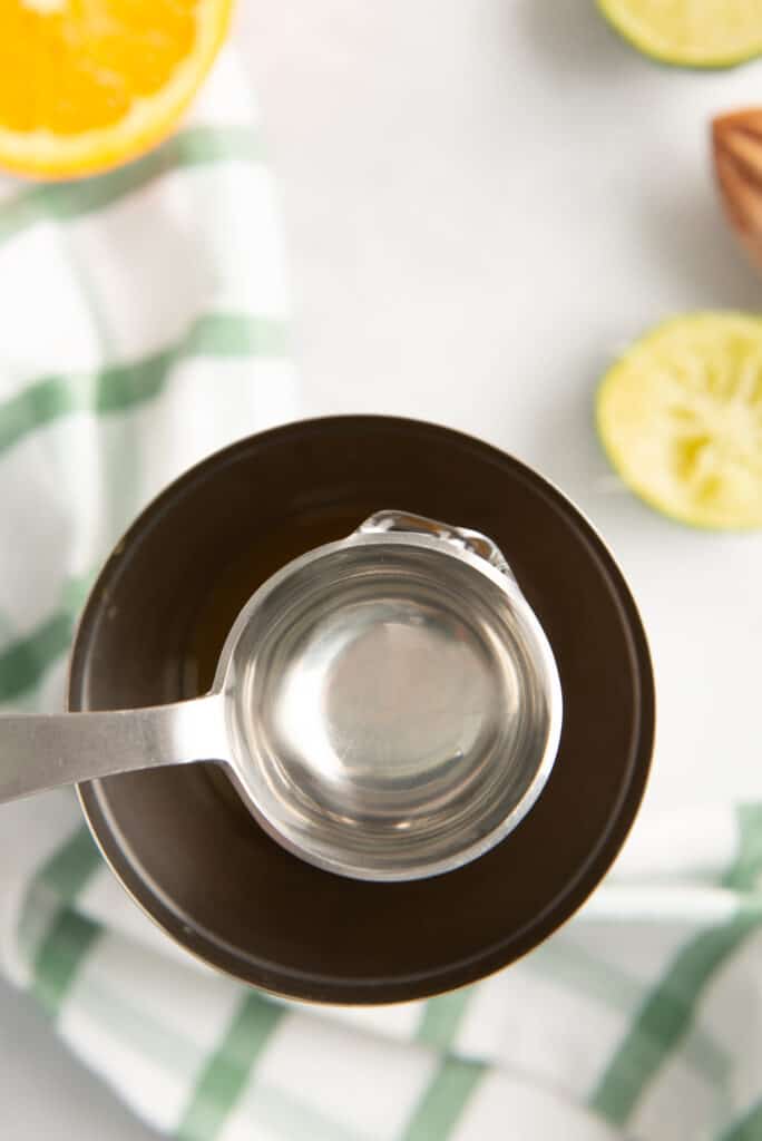 Simple syrup being added to a cocktail shaker for a drink