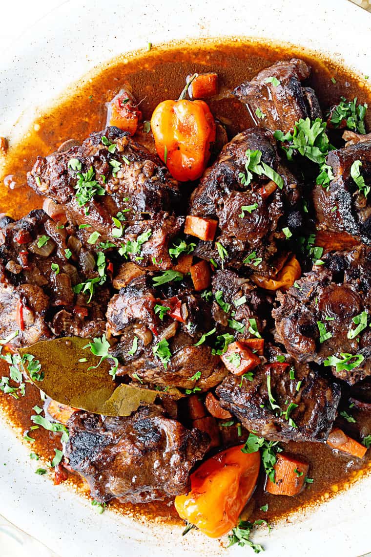 A close up of Jamaican oxtails swimming in a delicious sauce