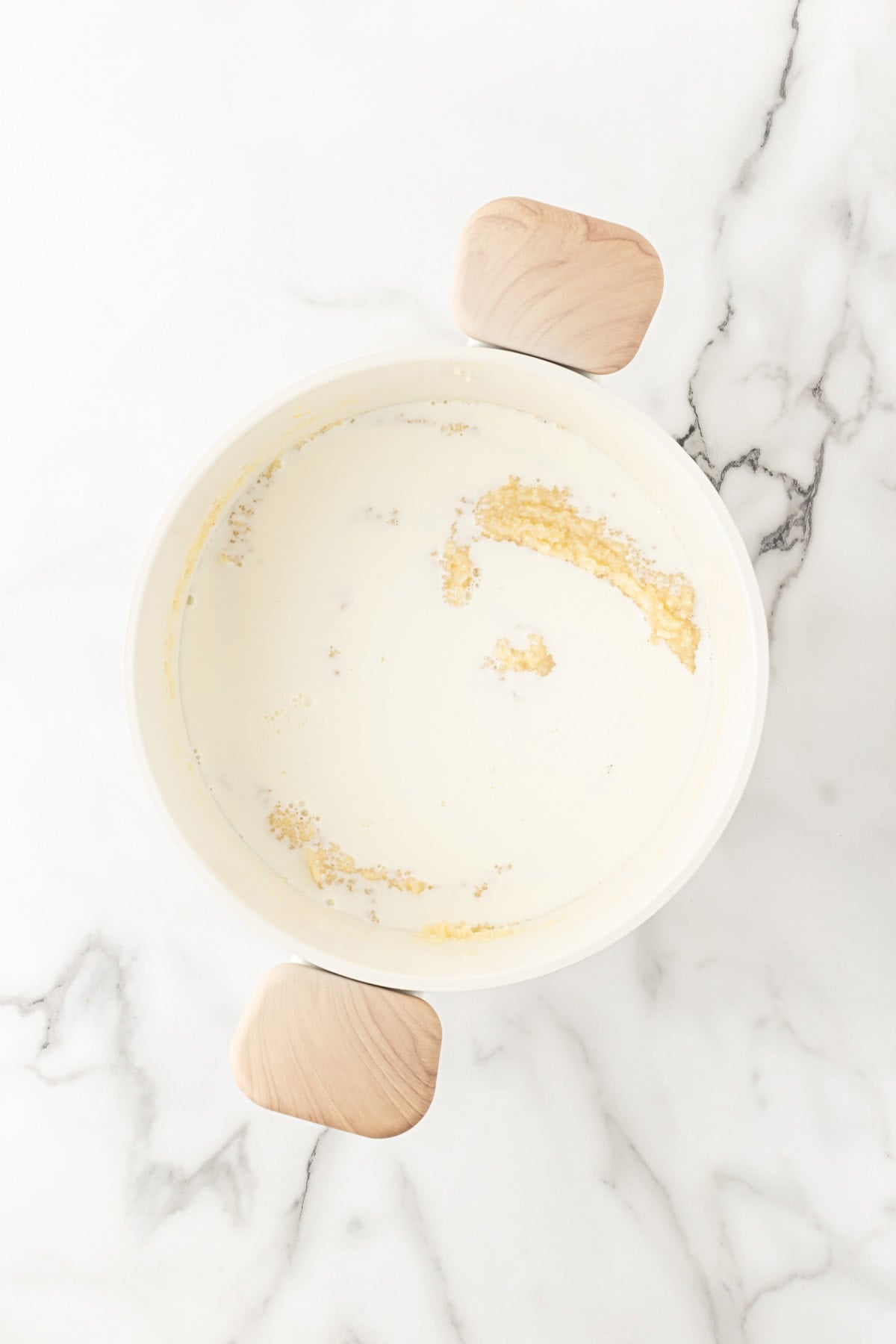 Milk added to the seasoned grits mixture in a saucepan