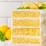 Closeup of the cut lemon layer cake, showing its three layers of yellow cake and frosting