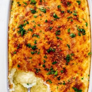 Perfect baked cheese grits casserole with spoon digging in ready to serve