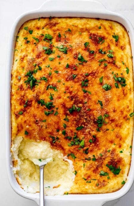 Perfect baked cheese grits casserole with spoon digging in ready to serve