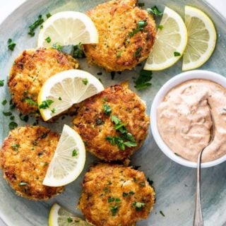 Gorgeous crab cakes scattered with lemon wedges and remoulade sauce ready to serve