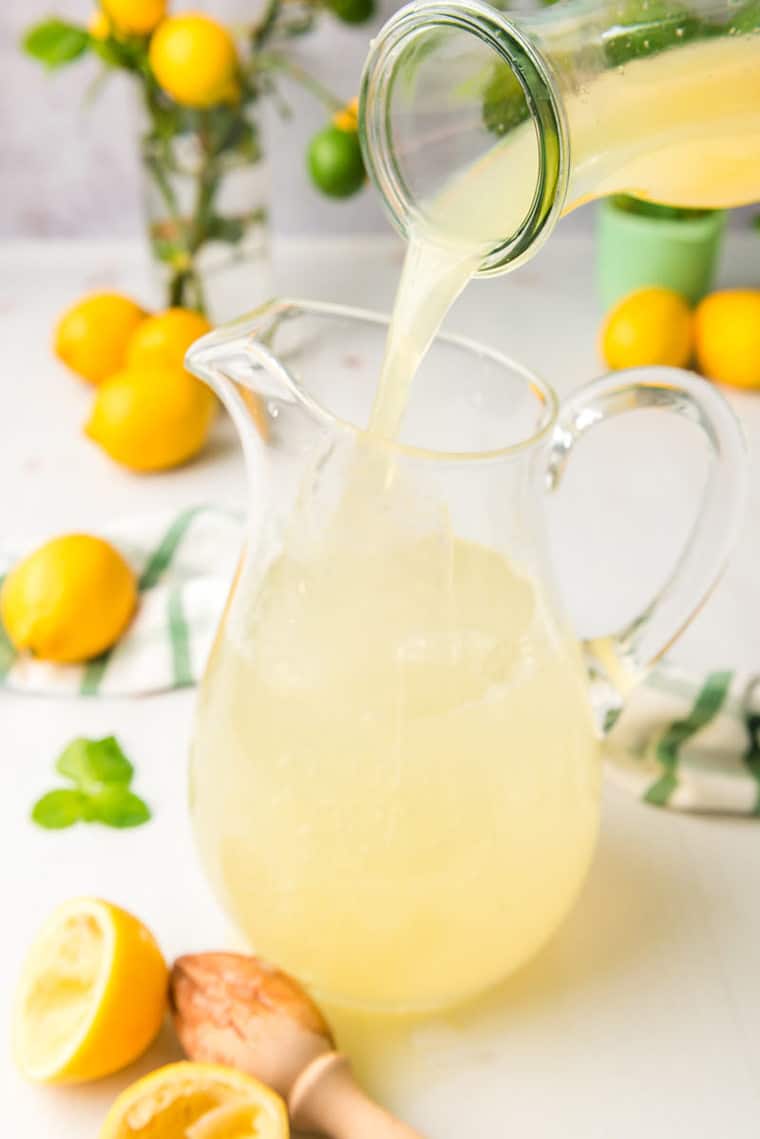 Fresh lemon juice being poured into pitcher