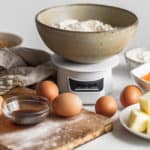 ingredients to bake with including flour, eggs, vanilla and butter set up