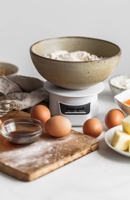 ingredients to bake with including flour, eggs, vanilla and butter set up