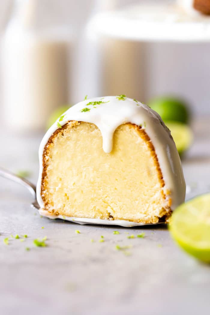 Key Lime cake slice with cream cheese glaze on cake server ready to serve on plate