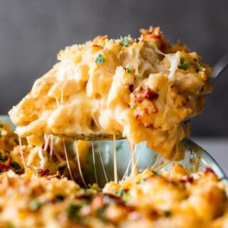 baked lobster mac and cheese on a spoon being lifted out of a dish