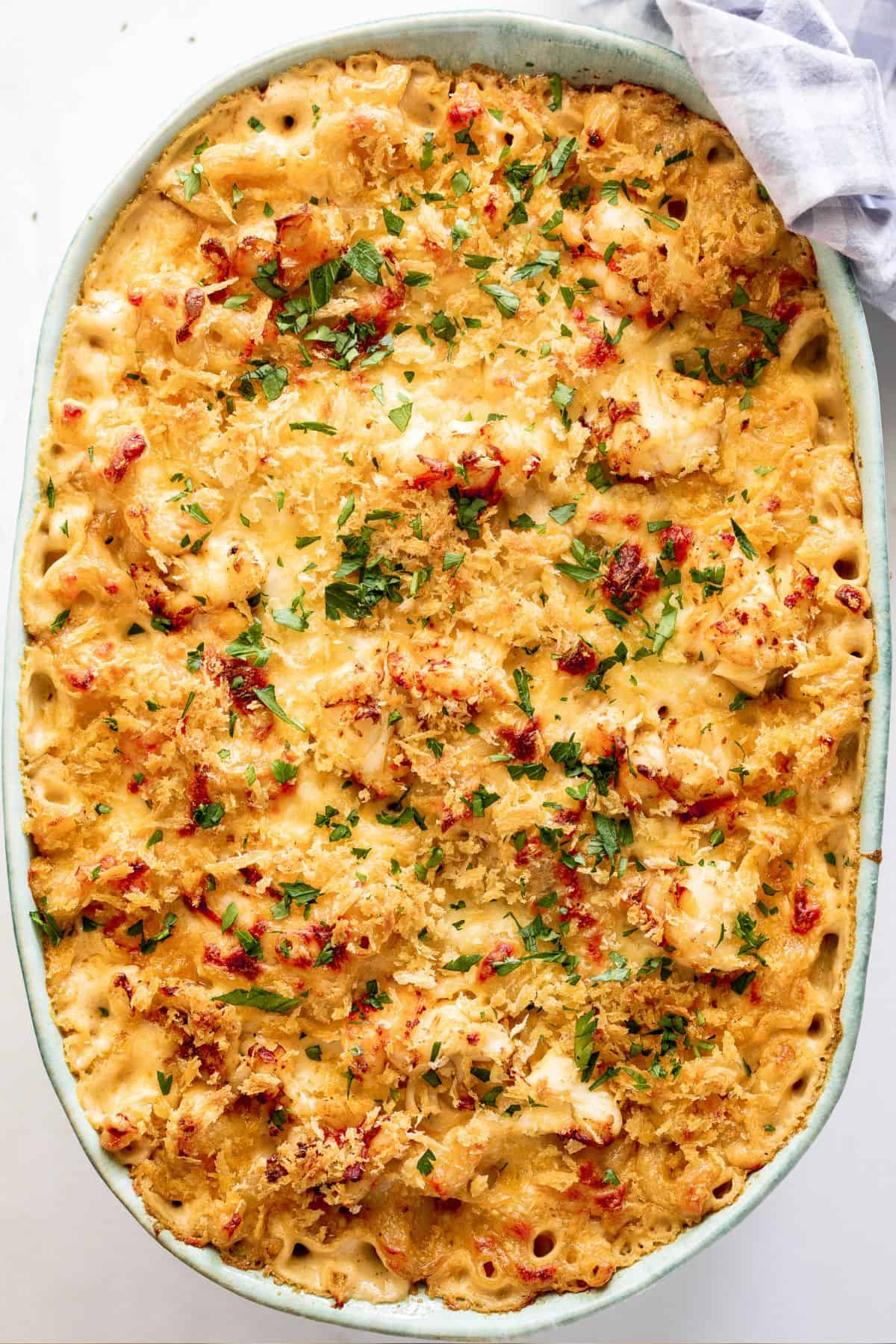 A large casserole dish with lobster mac and cheese ready to serve