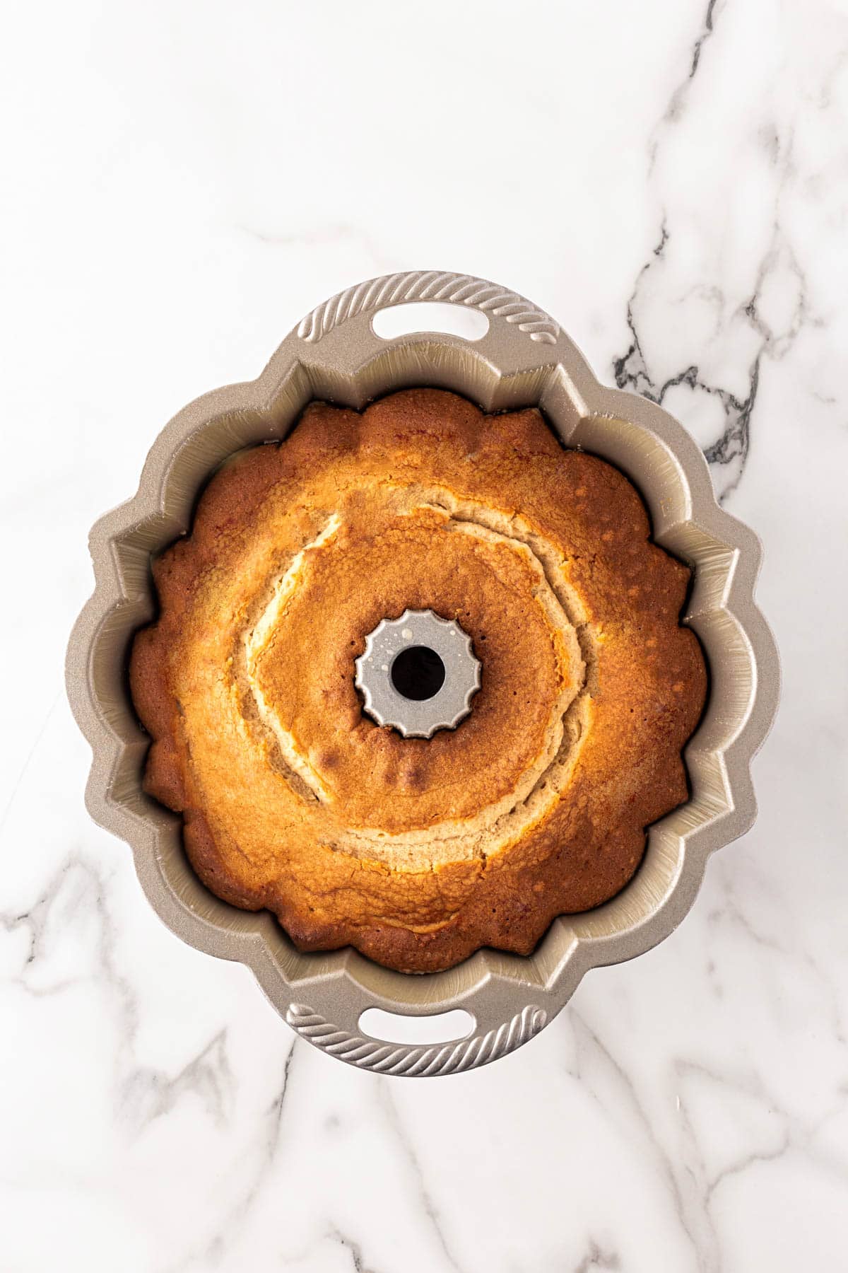 Golden baked key lime Bundt cake cooling in the pan after baking