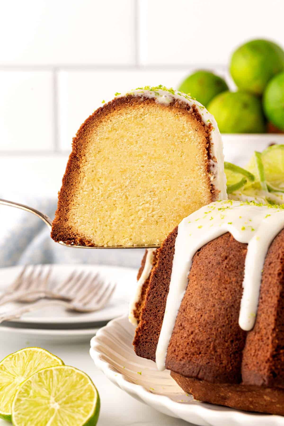 Closeup of a sliced key lime cake showing a moist, tender crumb with glaze dripping down the sides