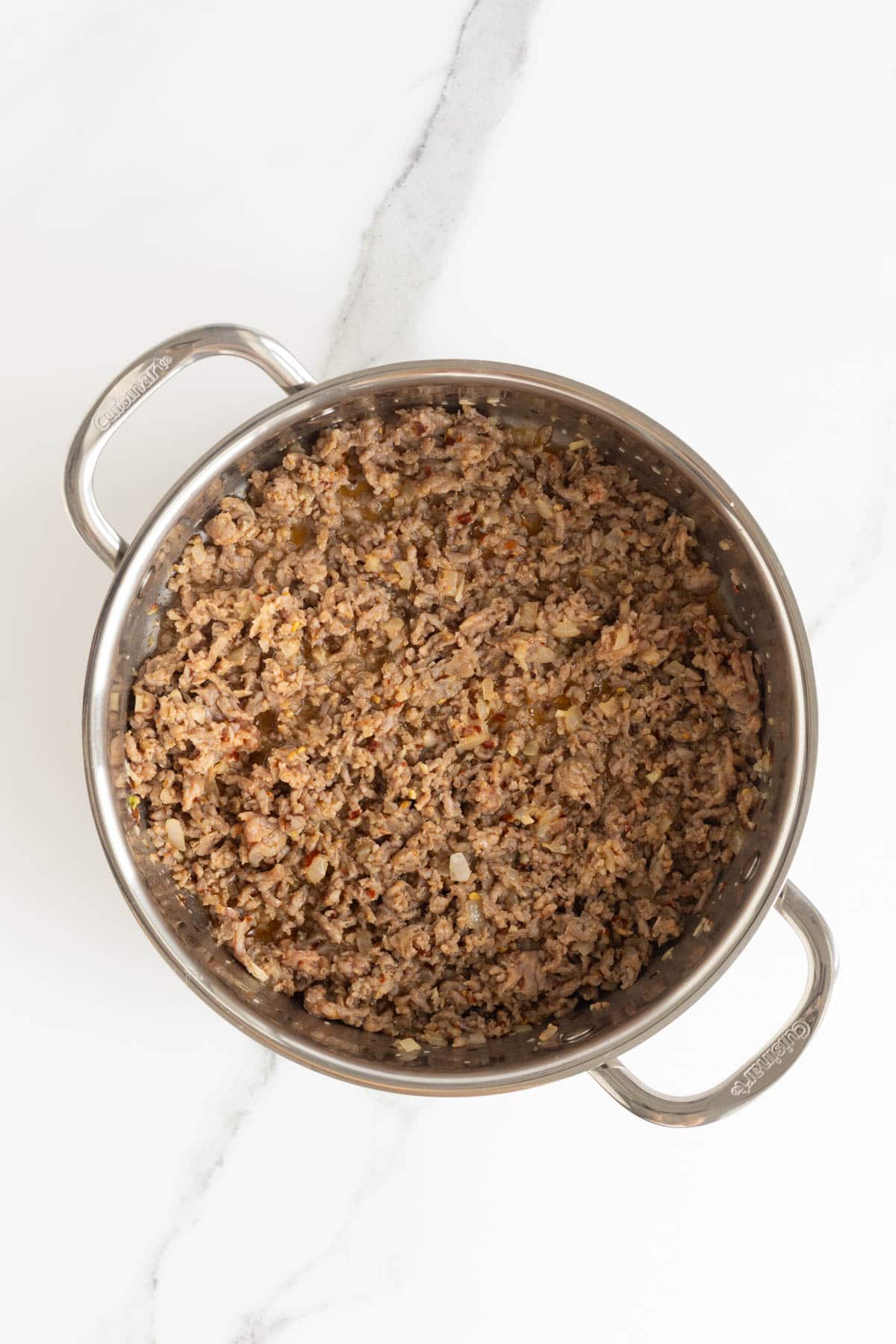Fully cooked and crumbled sausage with onion and spices in the pot