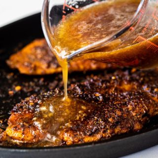 Blackened catfish with honey glaze being poured on top