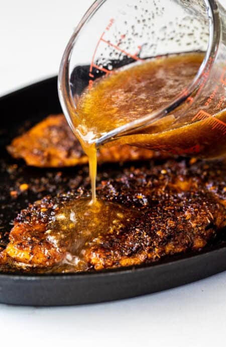 Blackened catfish with honey glaze being poured on top