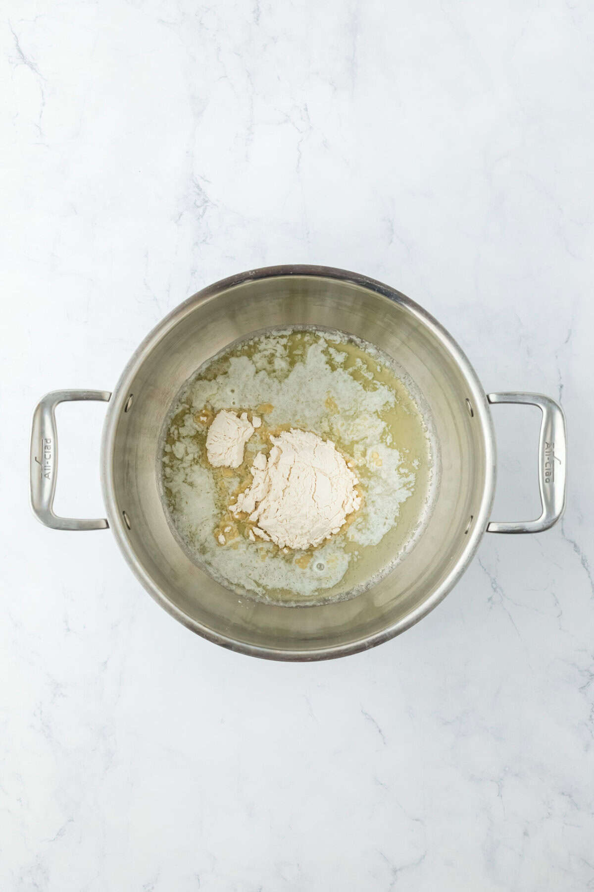 Flour being mixed into butter creating a roux