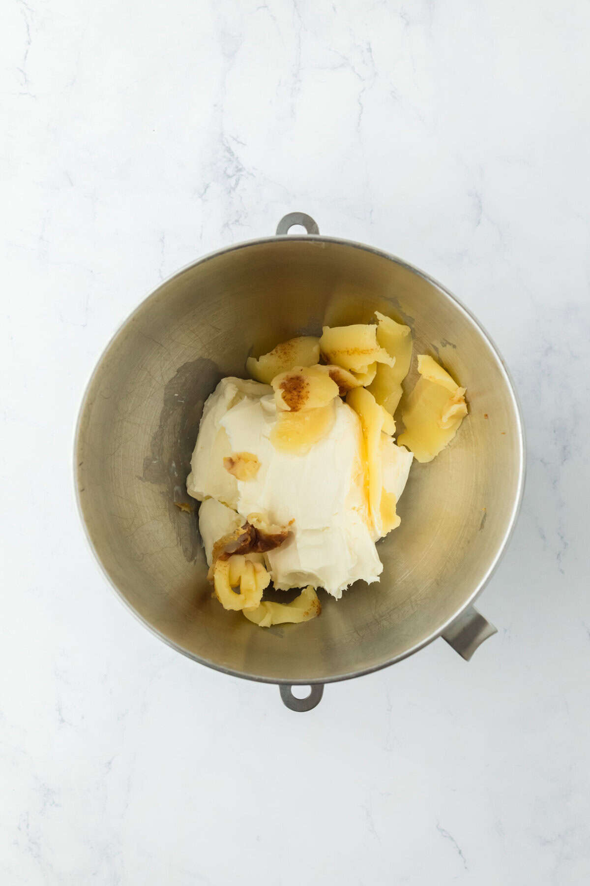 Cooled brown butter and cream cheese in a stand mixer bowl