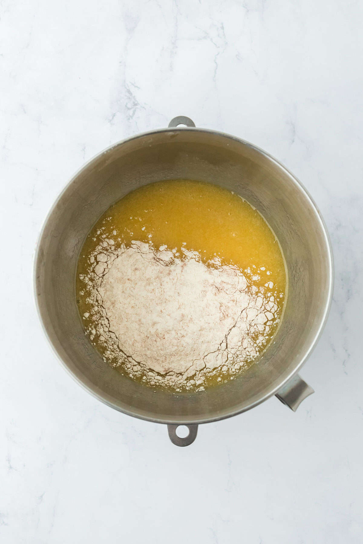 Flour being added to stand mixer bowl to mix in