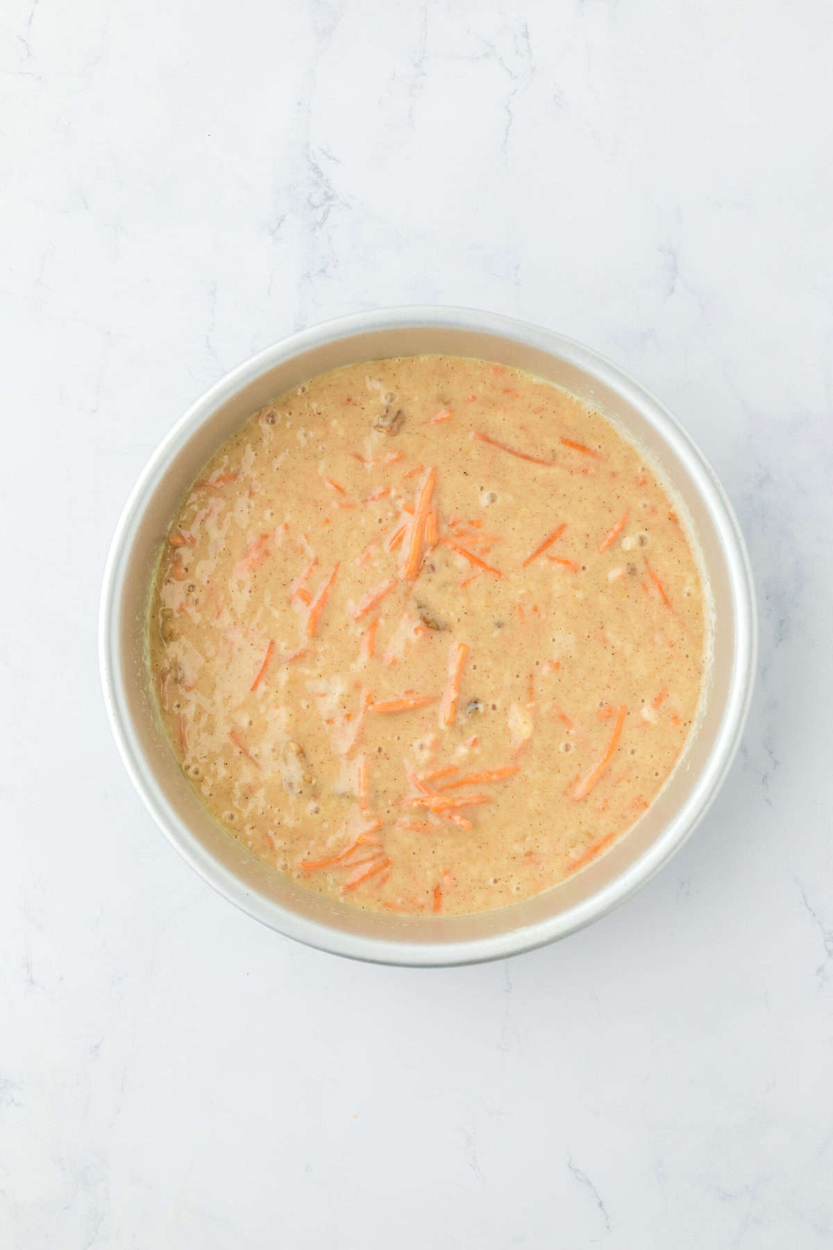 Carrot cake batter in a round pan before baking