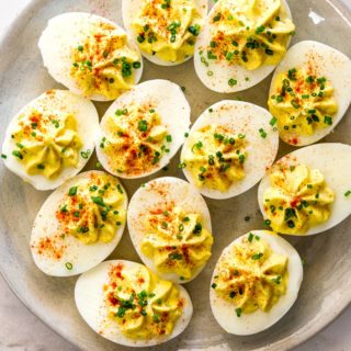 Deviled eggs placed on a beige platter ready to serve as an appetizer