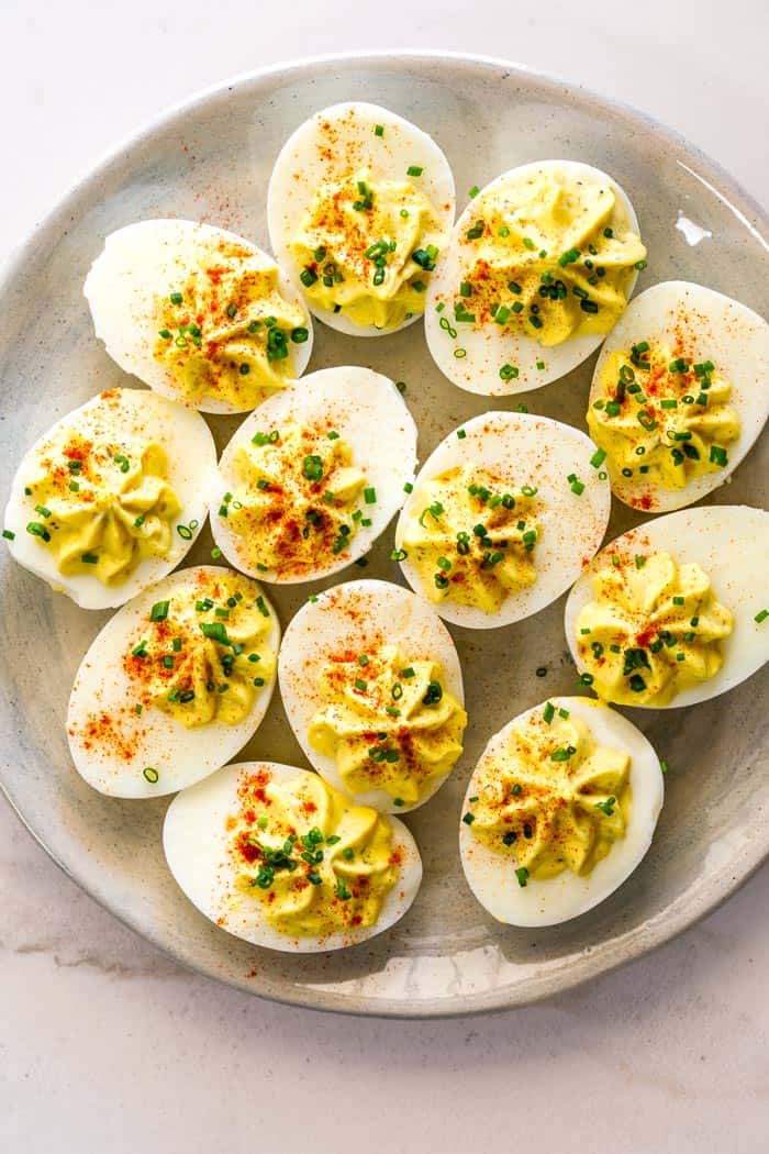 Deviled eggs placed on a beige platter ready to serve as an appetizer
