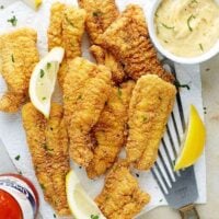 Perfectly fried catfish fillets with hot sauce, lemon wedges and tartar sauce