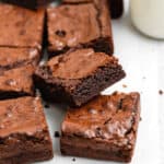 A close up of a batch of brownies with one stacked on top of another with the inside texture showing