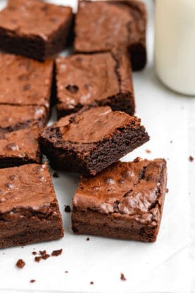 A close up of a batch of brownies with one stacked on top of another with the inside texture showing