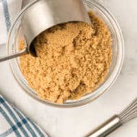 After learning how to make Brown sugar, it is being scooped into a measuring cup for baking