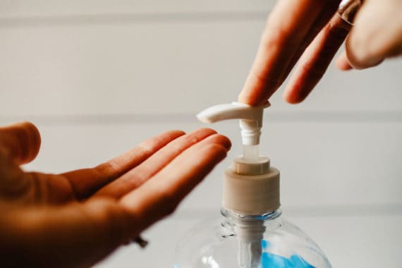 A person pumping sanitizer gel on their hands