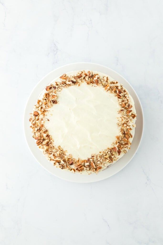 Frosting added to final cake with additional pecans added to the top