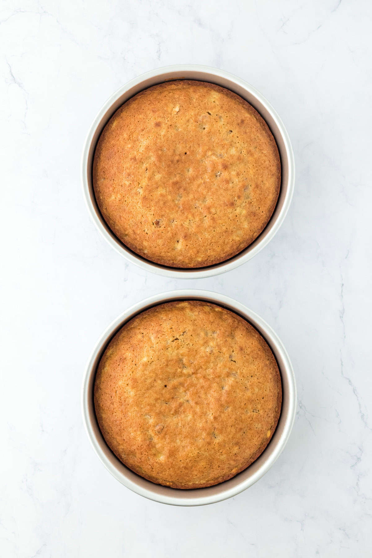 Baked layers of hummingbird cake recipe on white countertop