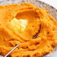 Classic and smooth mashed sweet potatoes with butter melting on it ready to serve