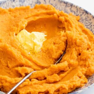 Classic and smooth mashed sweet potatoes with butter melting on it ready to serve