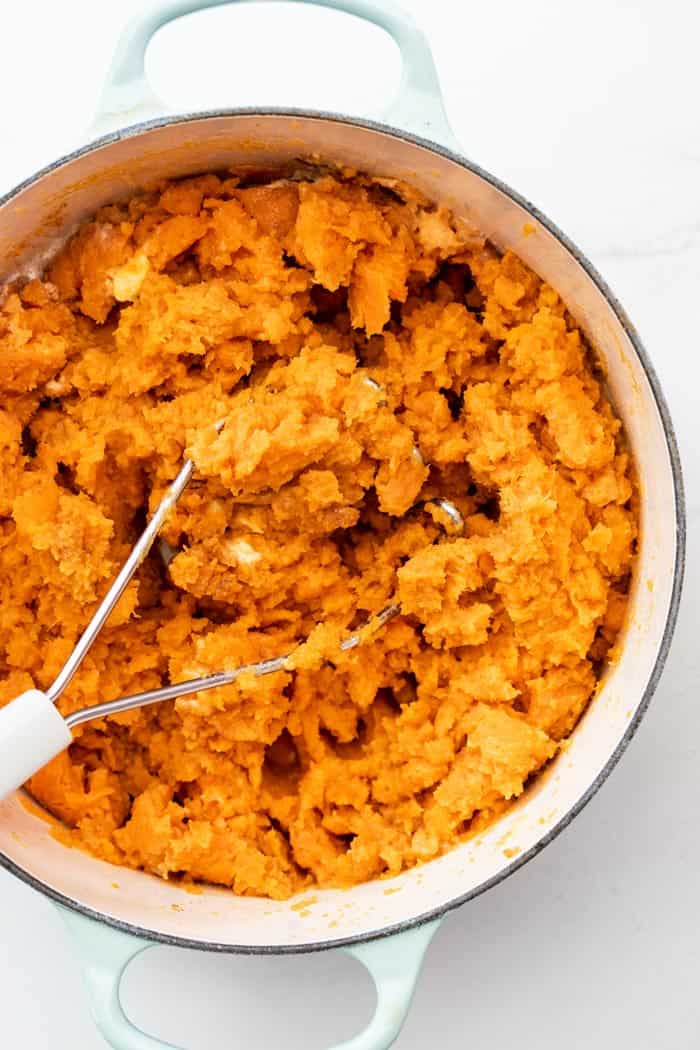 sweet potatoes being mashed up to serve